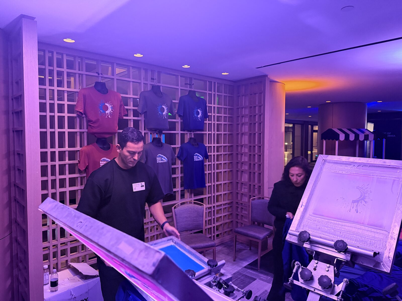 Wall of custom event shirts on display