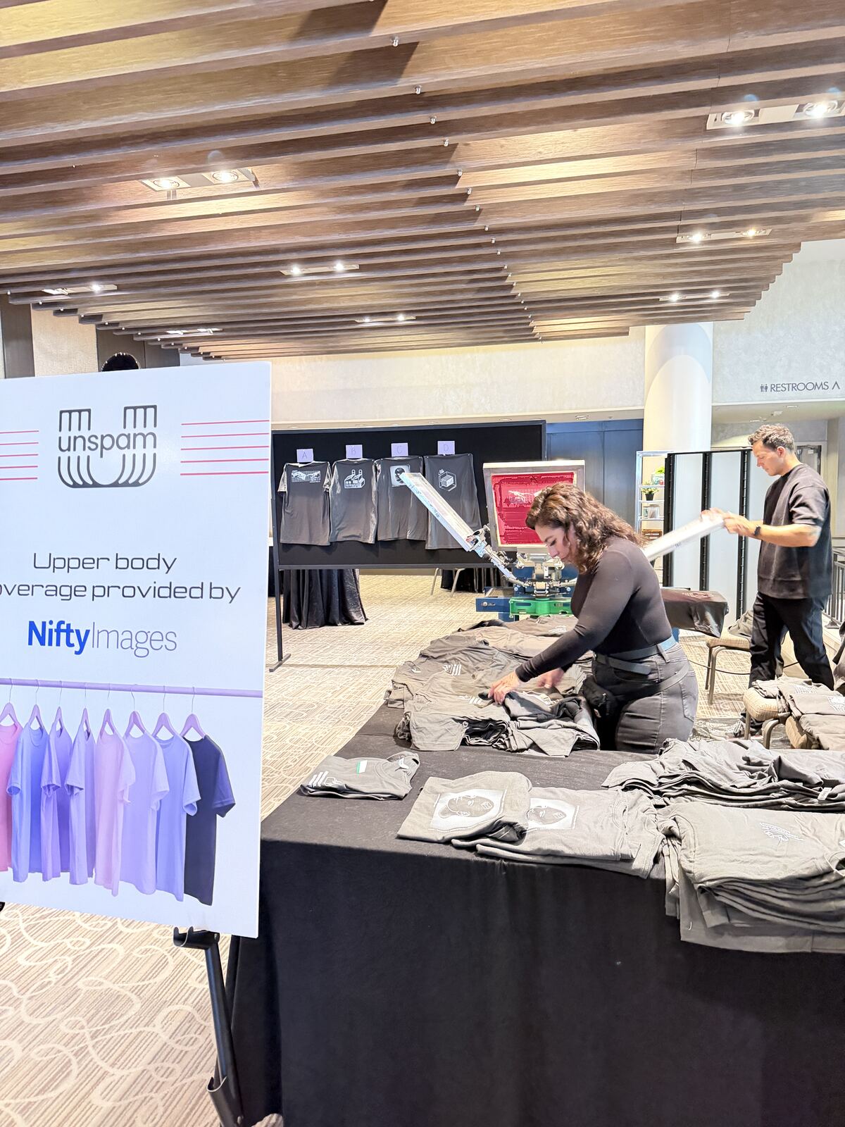 Person at an event booth examining and handling merchandise displays